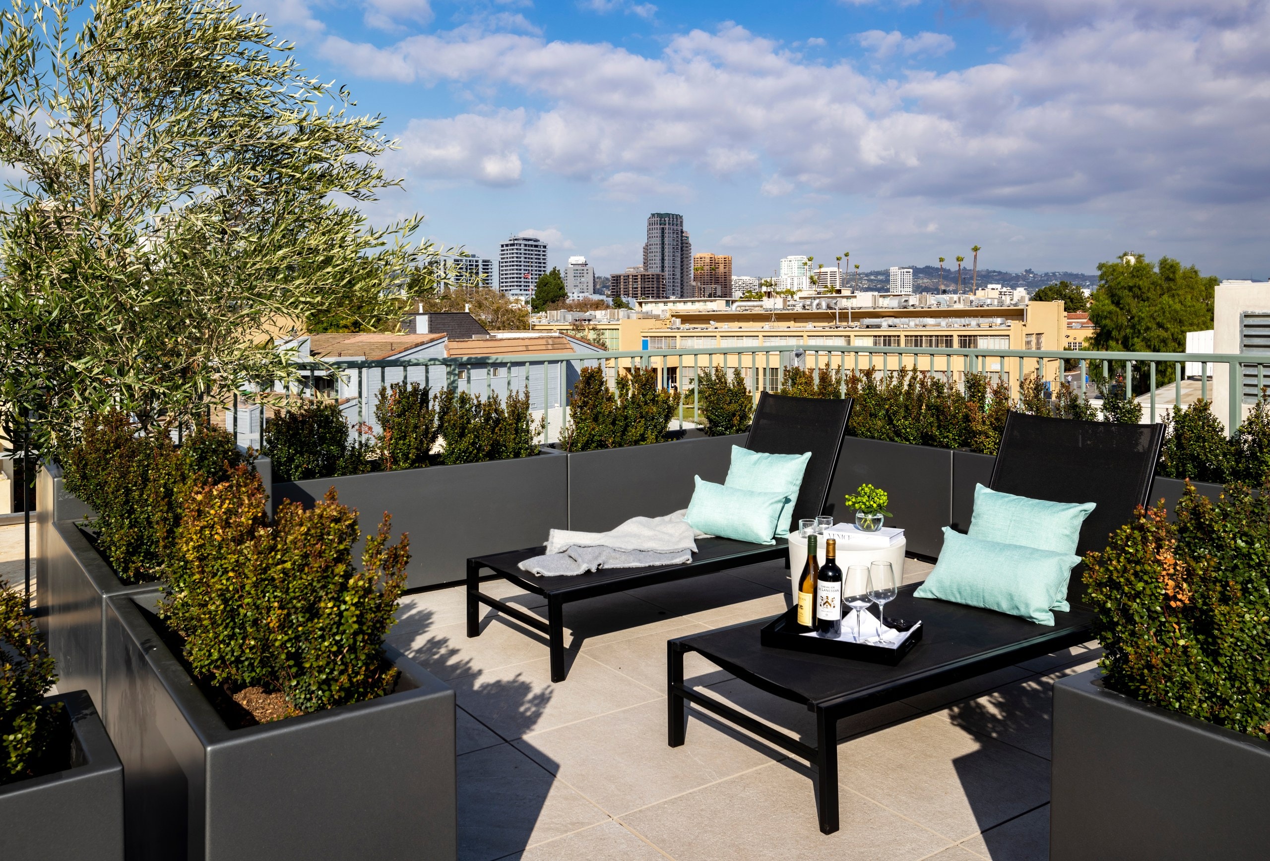 Rooftop lounge with the Westwood and Los Angeles skyline in daylight at Lumiere at Malcolm
